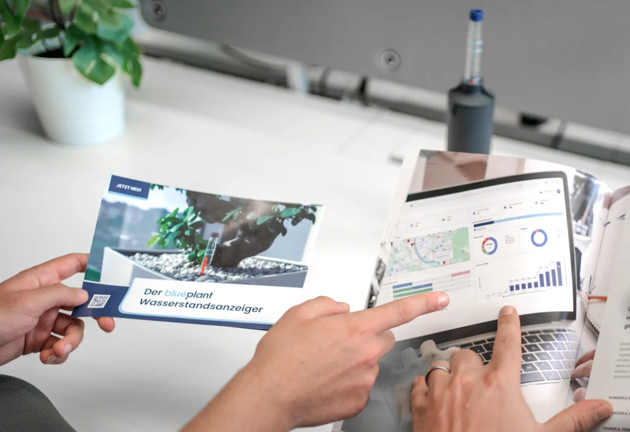 Gedruckter Flyer des blueplant-Wasserstandsmessers in der Hand