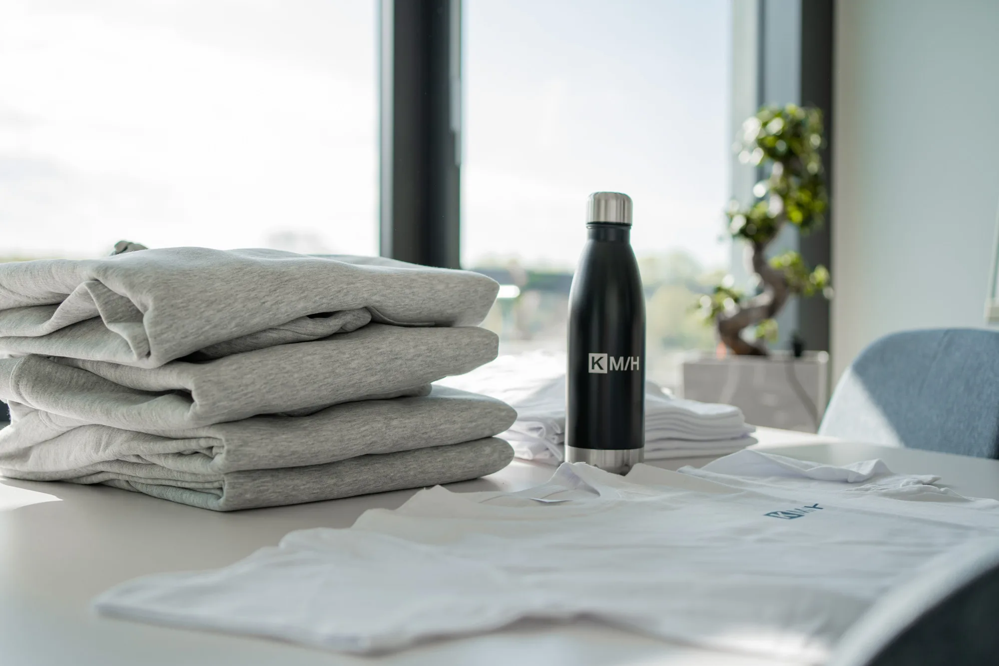 KMH-Merchandise, bedruckte Trinkflasche und Logo-T-Shirts