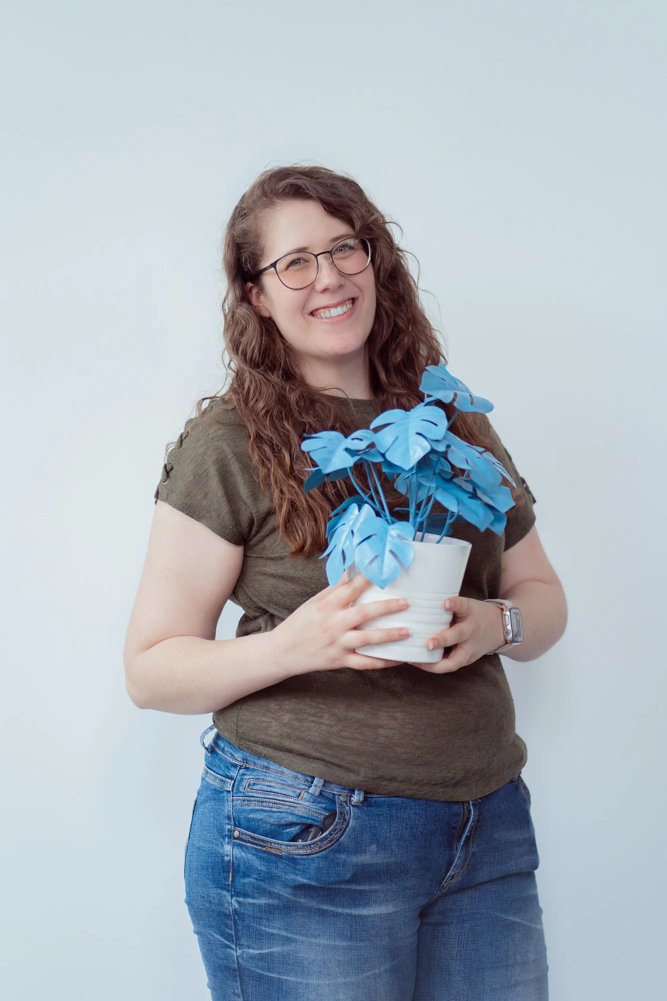 Einzelaufnahme eines Teammitglieds mit der blueplant-Plastikpflanze